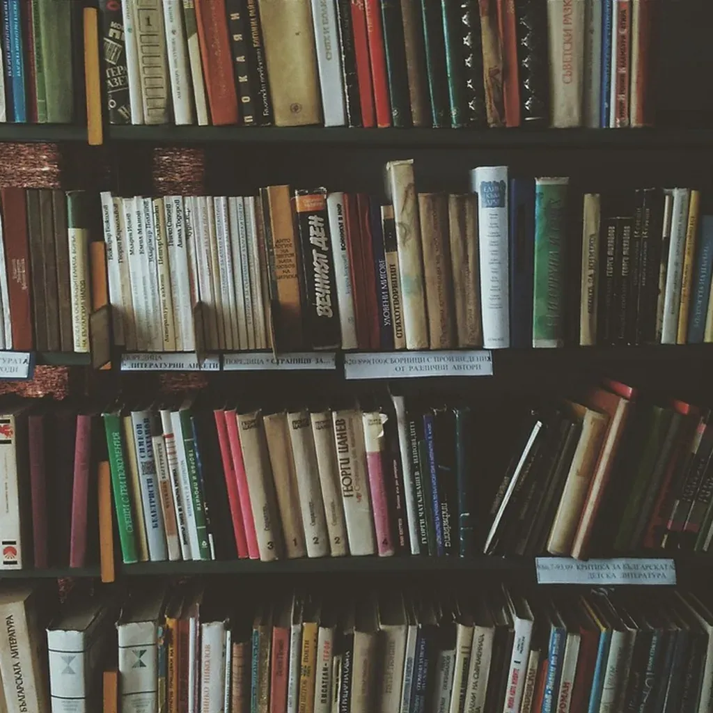 Bookshelf under a full book load Tall wooden bookcases packed with rows of books from floor to ceiling.