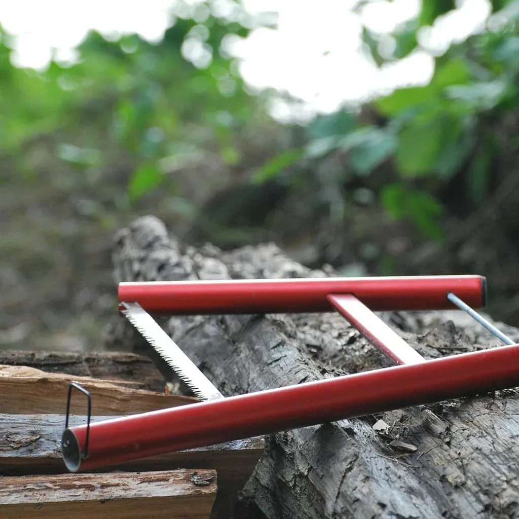 Clamping a workpiece without marring the surface A red bar clamp holding a length of timber steady against a rough work surface outdoors.