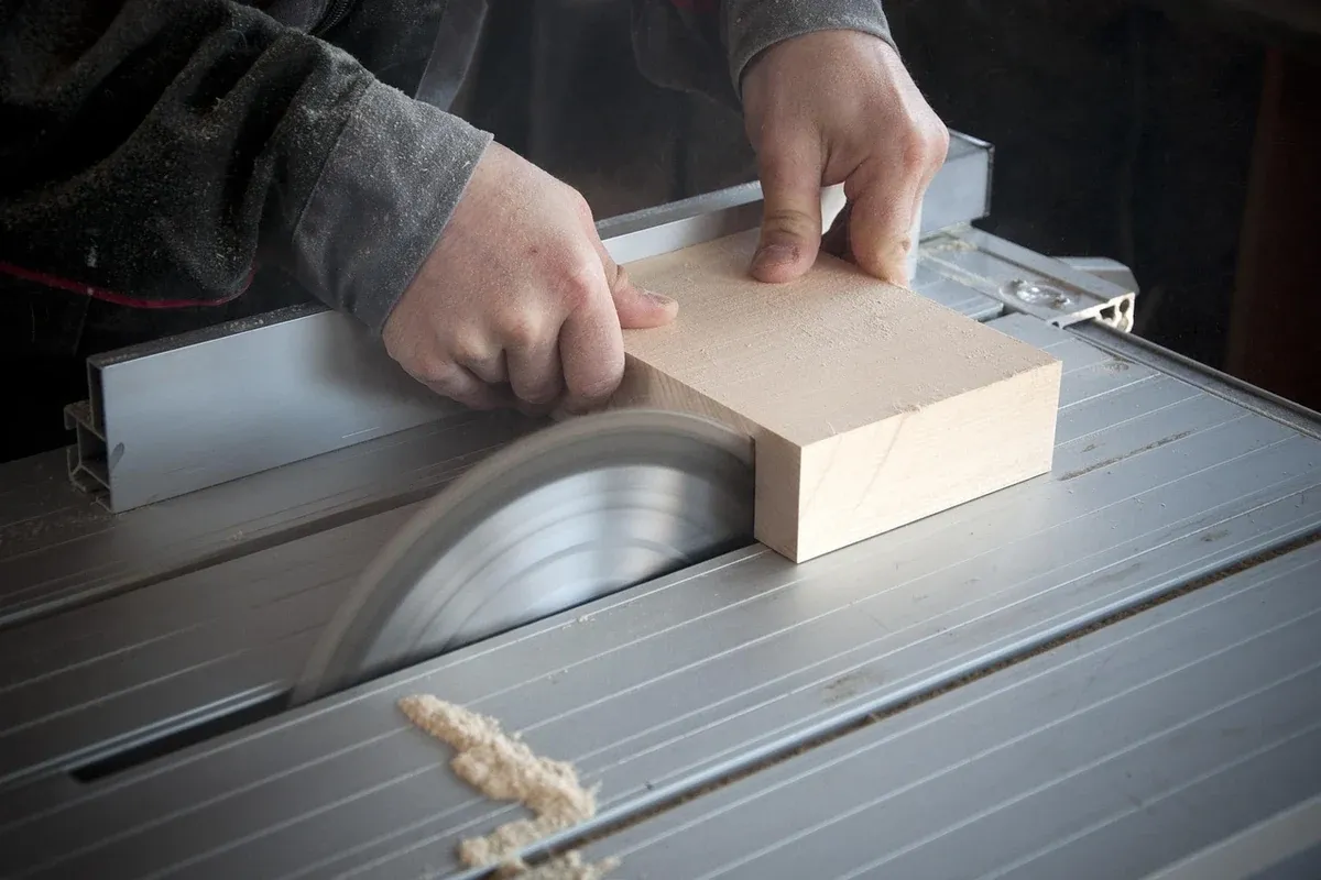 Woodworker cutting a board with a circular saw, sawdust flying, in a home workshop