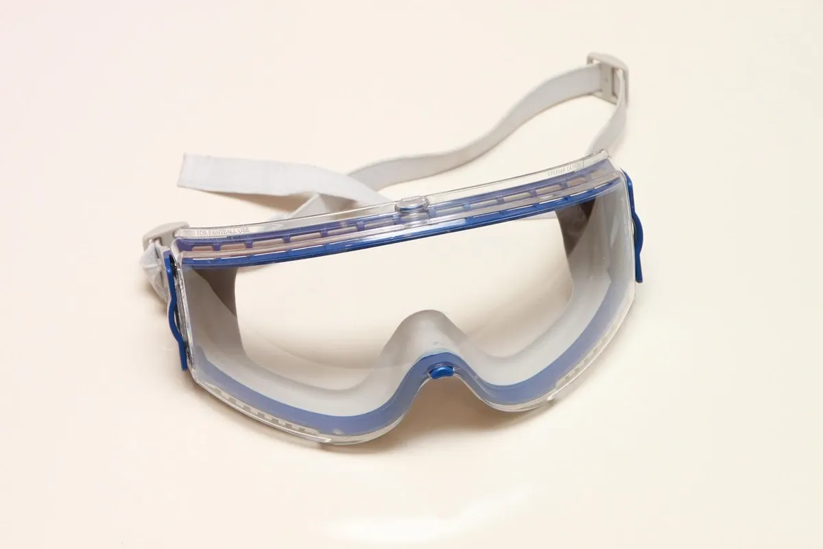 Clear safety glasses resting on a workbench next to woodworking tools