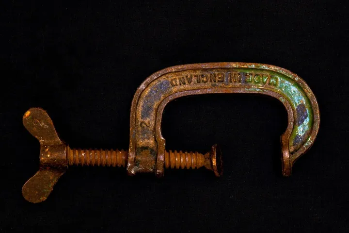 Metal G-clamp used to hold a woodworking piece in place